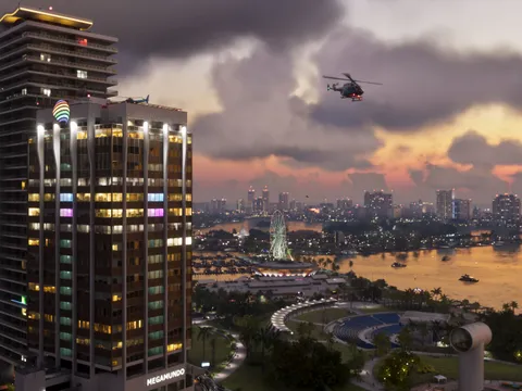 Vista de Vice City al atardecer con rascacielos y un helicóptero
